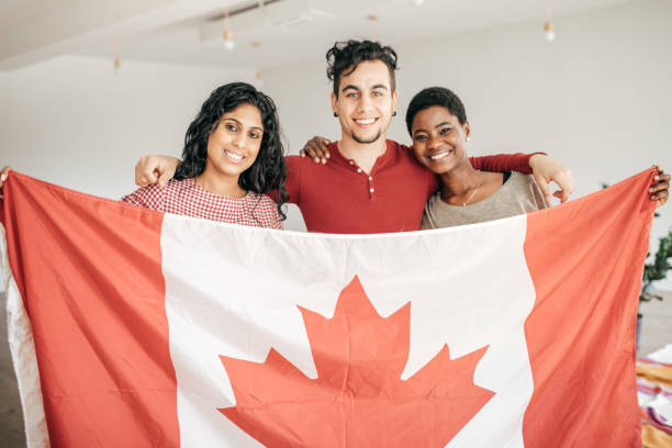 Étudiants souriant en tenant le drapeau du Canada